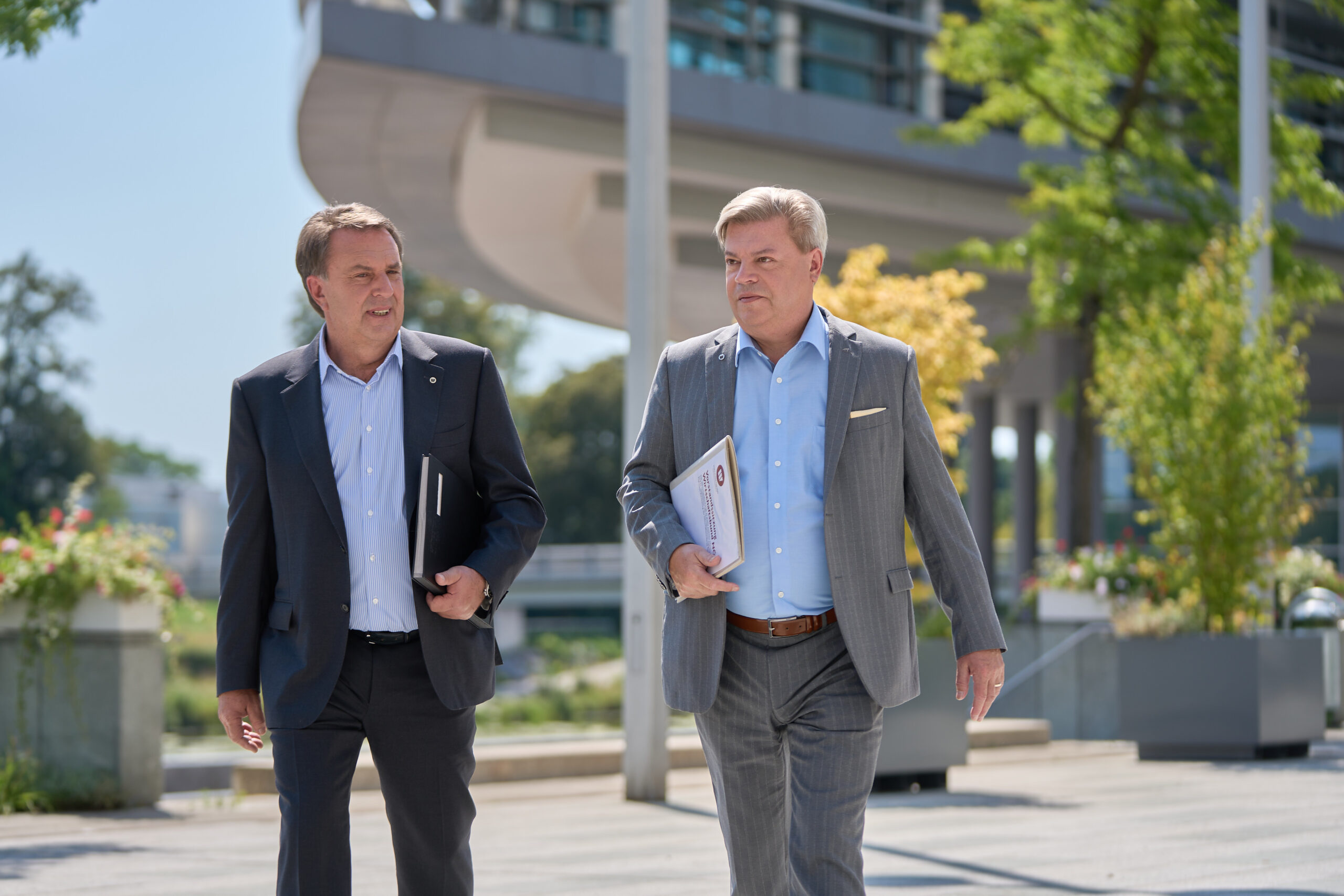 PM_2022-07-20_11-25-10 links Wolfgang Ecker gehend neben Harald Servus rechts ebenfalls gehend, beide befinden sich im Regierungsviertel in Sankt Pölten
