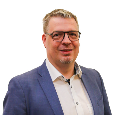 Am Bild zu sehen ist Dietmar Schöner, Fachgruppenobmann Gastronomie. Er trägt eine weißes Hemd mit blauem Sakko, Brille und kurzes dunkelblondes Haus, freundliches Lächeln.