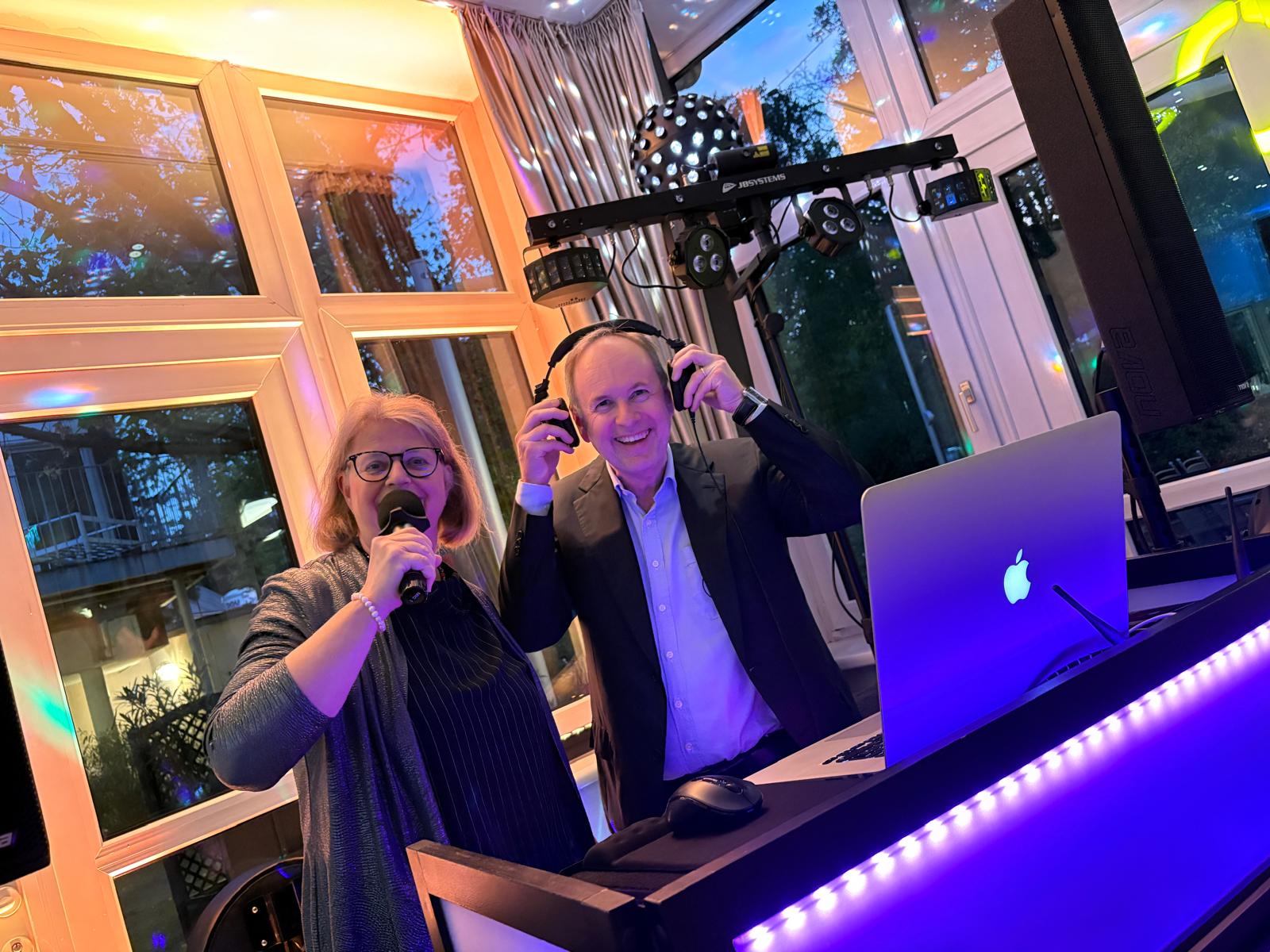 Am Bild zu sehen Obmann Erich Moser mit seiner Gattin Irene Meier Moser lachend am DJ Pult mit Kopfhörer und Mikrofon