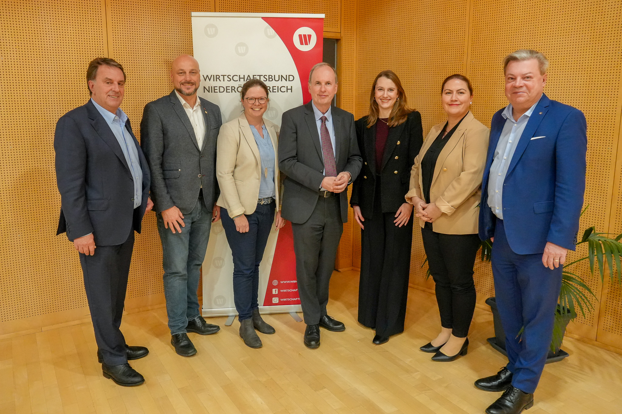 PA Wirtschaftsbund Wahlen im Bezirk Mödling Am Bild zu sehen der neue Bezirksgruppenvorstand mit Präsident Wolfgang Ecker und Landesgruppenobmann Harald Servus vor einer Holzwand